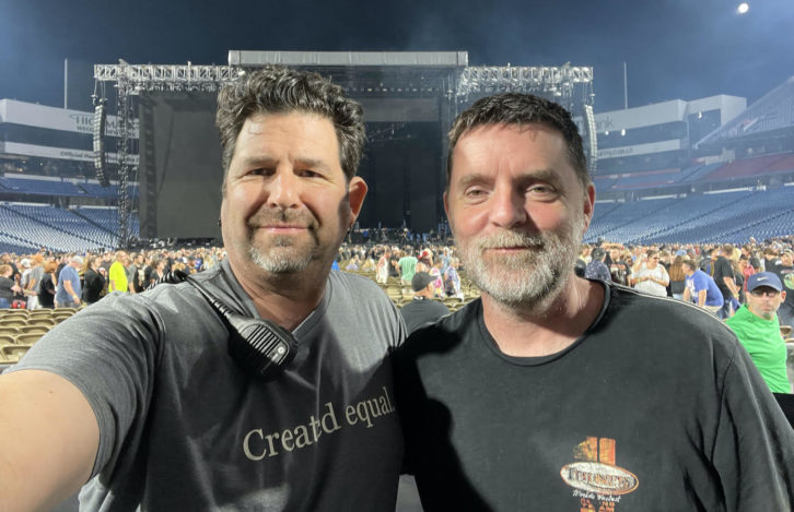 Инженеры Front-of-House Брент Карпентер (Mötley Crüe, слева) и Ронан МакХью (Def Leppard) отмечают проделанную работу еще за одну ночь, пока зрители уходят со стадиона Highmark в Буффало, штат Нью-Йорк.